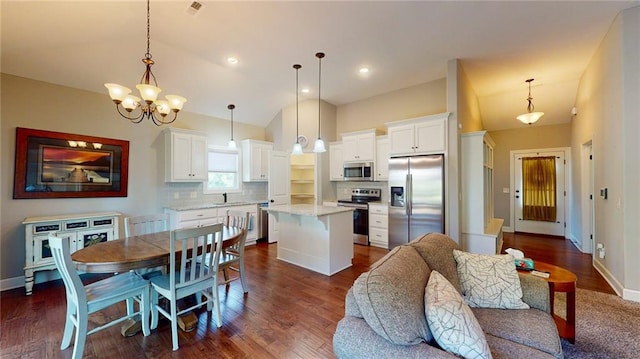 kitchen featuring a kitchen island, dark hardwood / wood-style floors, white cabinets, pendant lighting, and appliances with stainless steel finishes