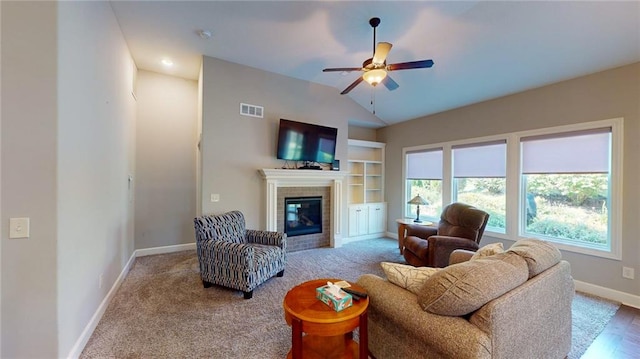 carpeted living room featuring a fireplace, ceiling fan, and vaulted ceiling