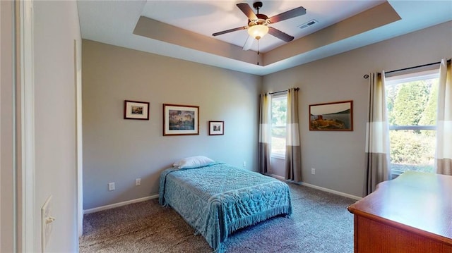 bedroom featuring a raised ceiling, carpet flooring, and ceiling fan