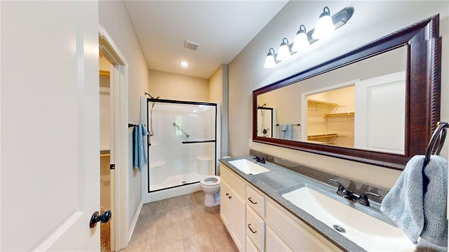 bathroom featuring vanity, tile patterned flooring, toilet, and a shower with shower door