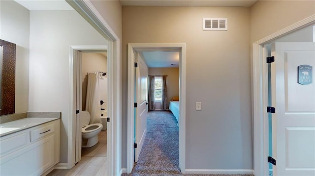 bathroom featuring vanity, tile patterned flooring, and toilet