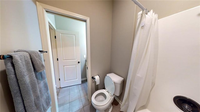 bathroom featuring walk in shower, toilet, and tile patterned flooring