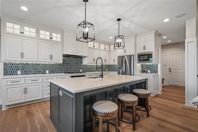 kitchen featuring white cabinets, an island with sink, and appliances with stainless steel finishes