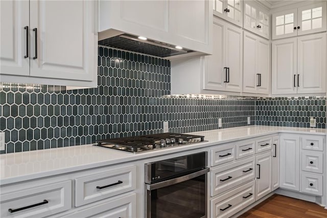 kitchen featuring white cabinets, backsplash, and appliances with stainless steel finishes