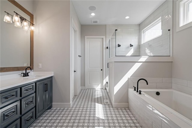 bathroom with vanity and shower with separate bathtub