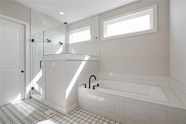 bathroom featuring shower with separate bathtub