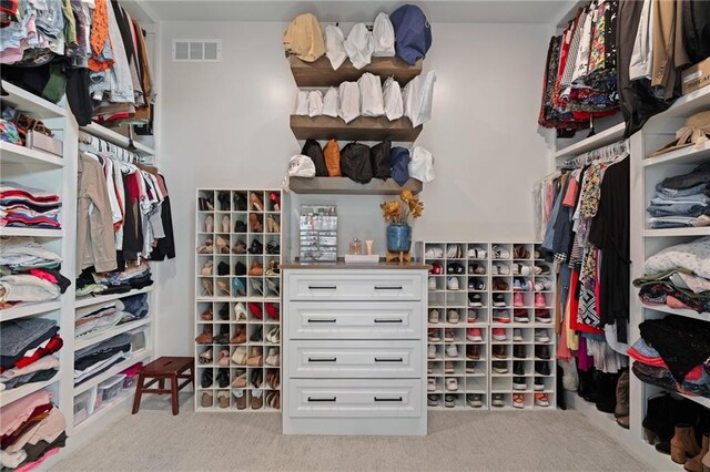 walk in closet featuring light carpet