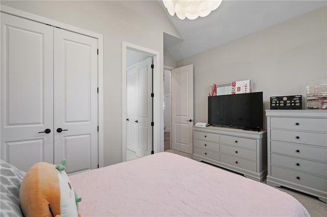 carpeted bedroom with a closet and lofted ceiling