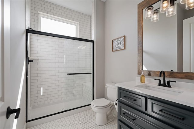 bathroom featuring tile patterned flooring, vanity, toilet, and an enclosed shower