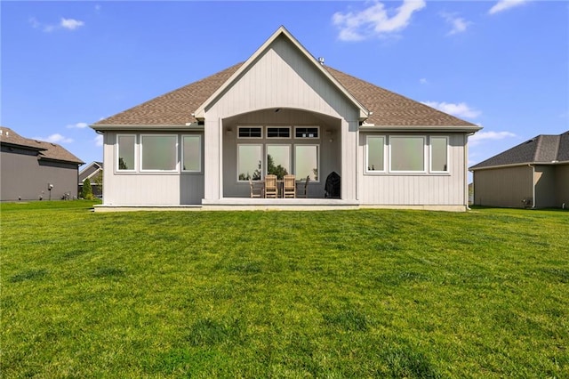 rear view of house featuring a lawn