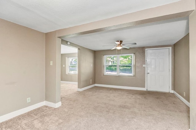 empty room with ceiling fan and light carpet