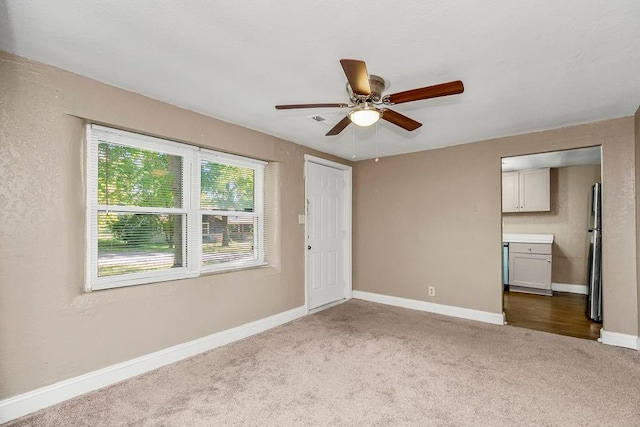 unfurnished room featuring ceiling fan and carpet floors