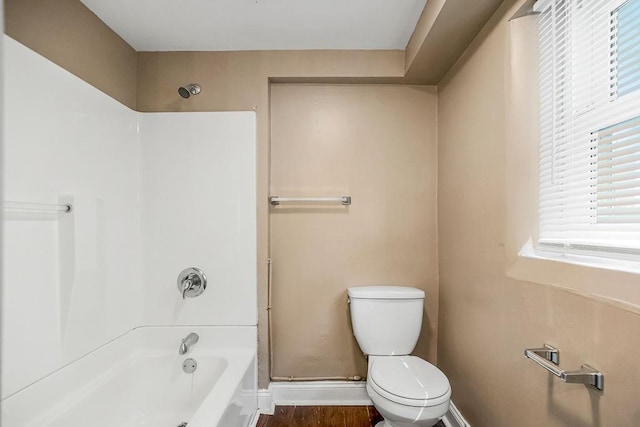 bathroom featuring shower / bathtub combination, hardwood / wood-style floors, and toilet