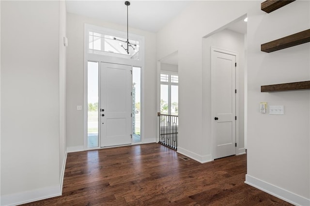 entryway with dark hardwood / wood-style floors and a chandelier