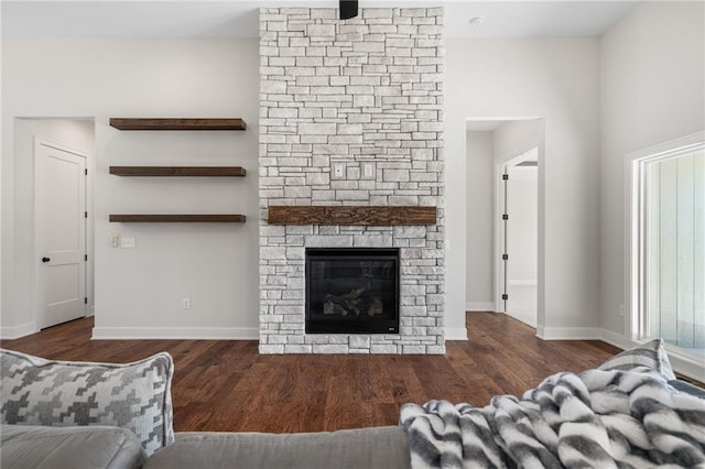 living room with a fireplace and dark wood-type flooring