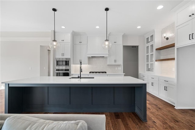 kitchen with appliances with stainless steel finishes, a large island, and white cabinets