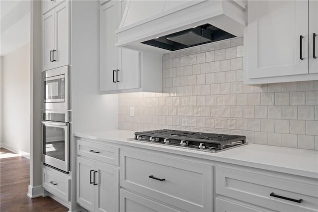 kitchen with white cabinetry, appliances with stainless steel finishes, and custom exhaust hood