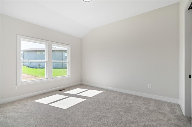 carpeted empty room featuring lofted ceiling