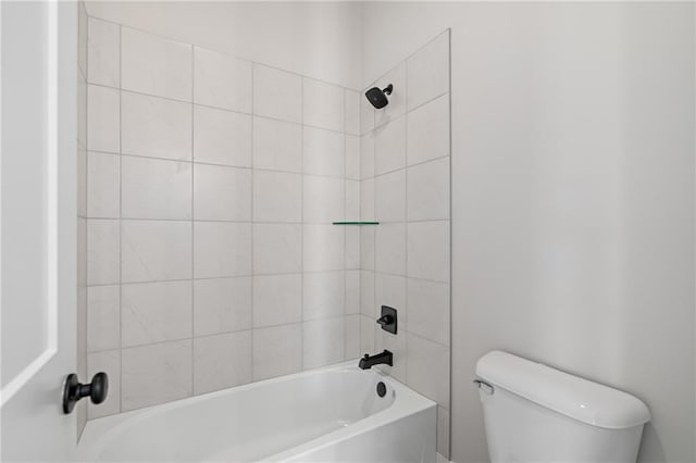 bathroom featuring tiled shower / bath combo and toilet