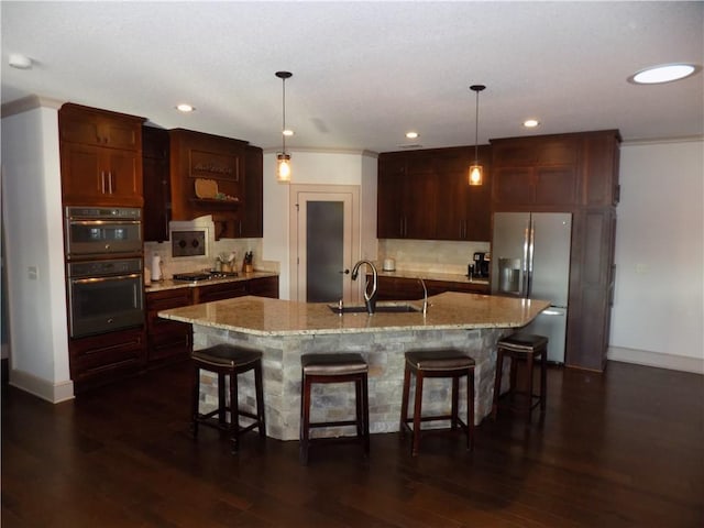 kitchen with pendant lighting, sink, appliances with stainless steel finishes, and dark wood-type flooring