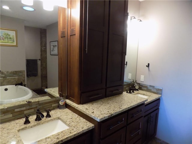 bathroom with backsplash, a bathtub, and vanity