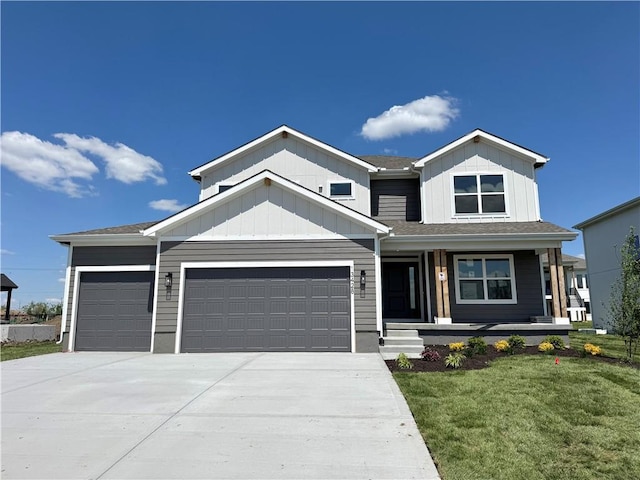 view of front of home with covered porch, driveway, a garage, a front yard, and board and batten siding