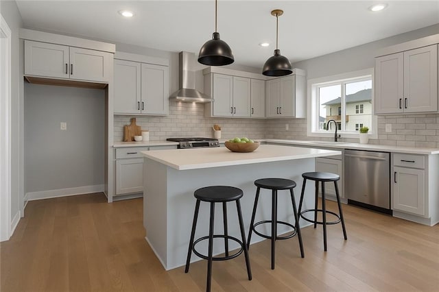 13428 W 178th St, Overland Park, KS 66013 - kitchen with stainless steel appliances, wall chimney exhaust hood, light wood-style floors, a breakfast bar, and recessed lighting