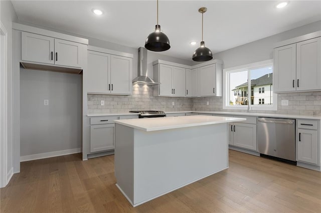 13428 W 178th St, Overland Park, KS 66013 - kitchen with appliances with stainless steel finishes, wall chimney range hood, tasteful backsplash, light countertops, and light wood finished floors