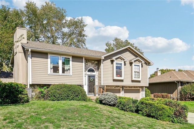 bi-level home featuring a front lawn and a garage