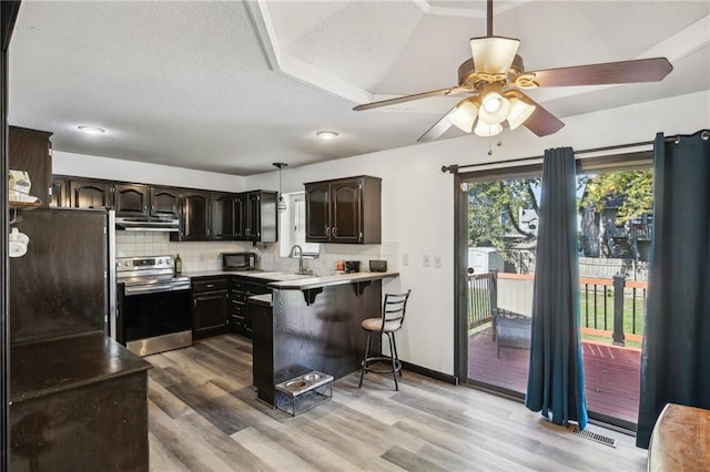 kitchen with dark brown cabinets, light hardwood / wood-style flooring, kitchen peninsula, and electric range