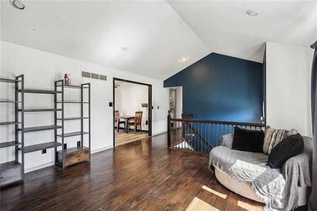 living area featuring vaulted ceiling and dark hardwood / wood-style flooring