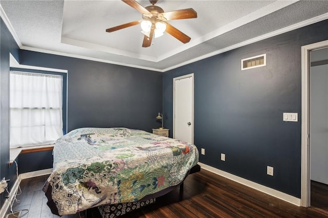 bedroom featuring ceiling fan, a tray ceiling, dark hardwood / wood-style floors, and crown molding