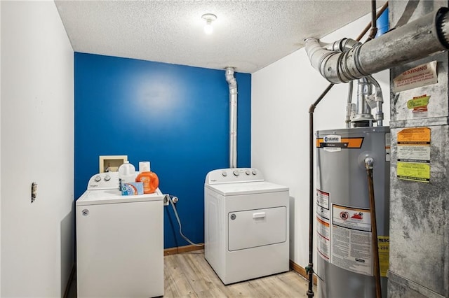 washroom with gas water heater, light hardwood / wood-style floors, separate washer and dryer, and a textured ceiling