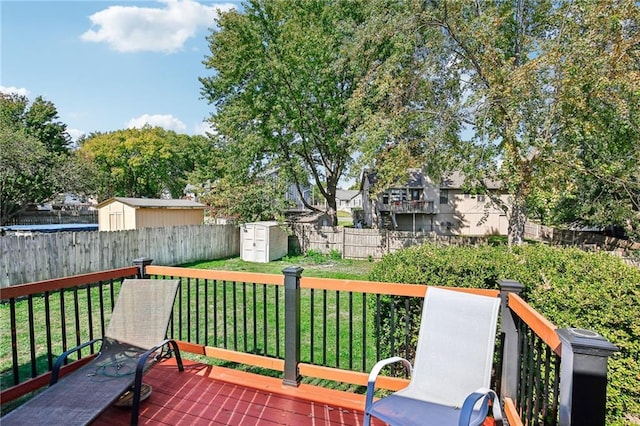 wooden terrace with a storage shed and a yard