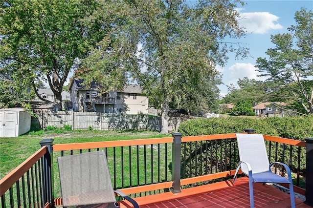 wooden deck with a yard and a storage unit