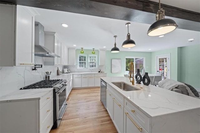 8301 Lee Blvd, Leawood, KS 66206 - kitchen with an island with sink, wall chimney exhaust hood, white cabinets, recessed lighting, and appliances with stainless steel finishes