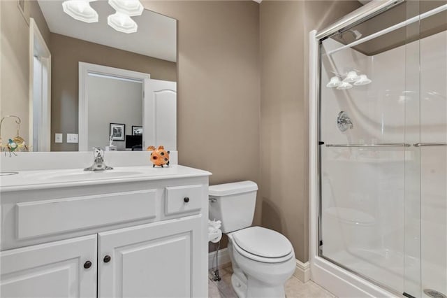 bathroom featuring baseboards, toilet, a stall shower, tile patterned floors, and vanity