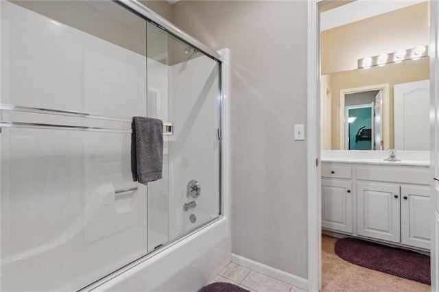 full bathroom featuring tile patterned flooring, vanity, baseboards, and bath / shower combo with glass door