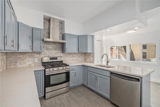 kitchen with sink, wall chimney exhaust hood, stainless steel appliances, tasteful backsplash, and kitchen peninsula