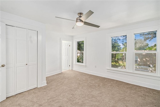 unfurnished bedroom featuring ceiling fan and light colored carpet