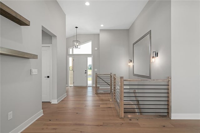 entryway with high vaulted ceiling and hardwood / wood-style flooring