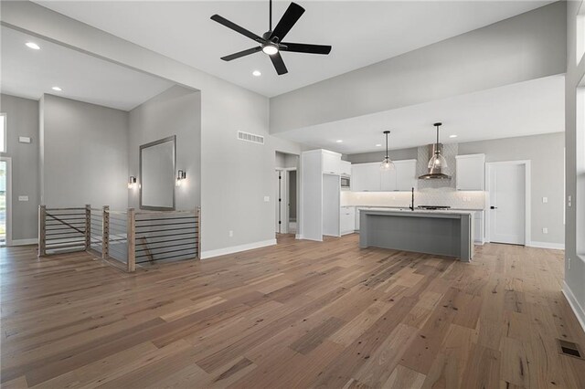 unfurnished living room with light hardwood / wood-style flooring and sink