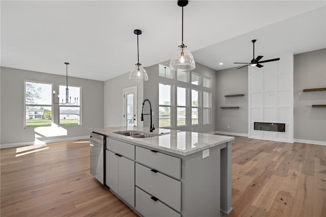 kitchen with dishwasher, light hardwood / wood-style floors, a kitchen island with sink, and sink