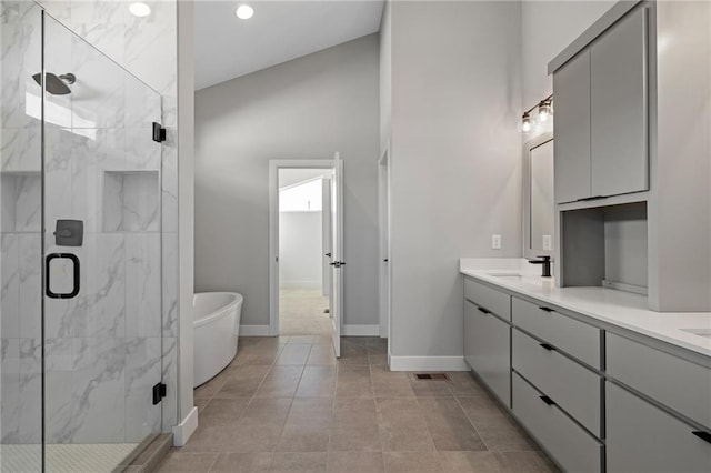 bathroom with tile patterned flooring, independent shower and bath, and vanity