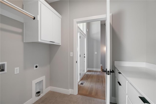 washroom featuring hookup for a washing machine, cabinets, light hardwood / wood-style flooring, and hookup for an electric dryer