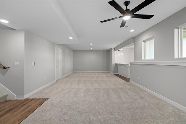 basement with light carpet and ceiling fan