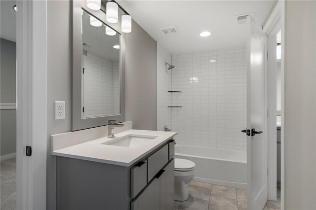 full bathroom with tile patterned flooring, tiled shower / bath combo, vanity, and toilet