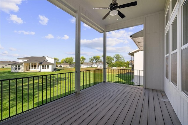 wooden deck featuring a lawn and ceiling fan