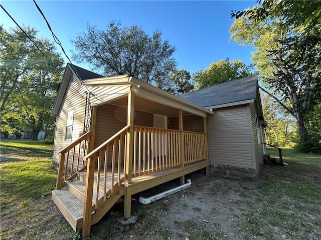 rear view of house featuring a lawn and a deck