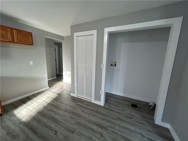 unfurnished bedroom with a closet and dark hardwood / wood-style floors